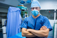 Portrait of surgeon standing with arms crossed in operation room Photo d'un docteur dans une salle d'opération