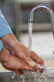 Image d'une personne en train de se laver les mains sous l'eau