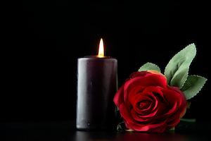 Photo de deuil avec une bougie et une rose rouge